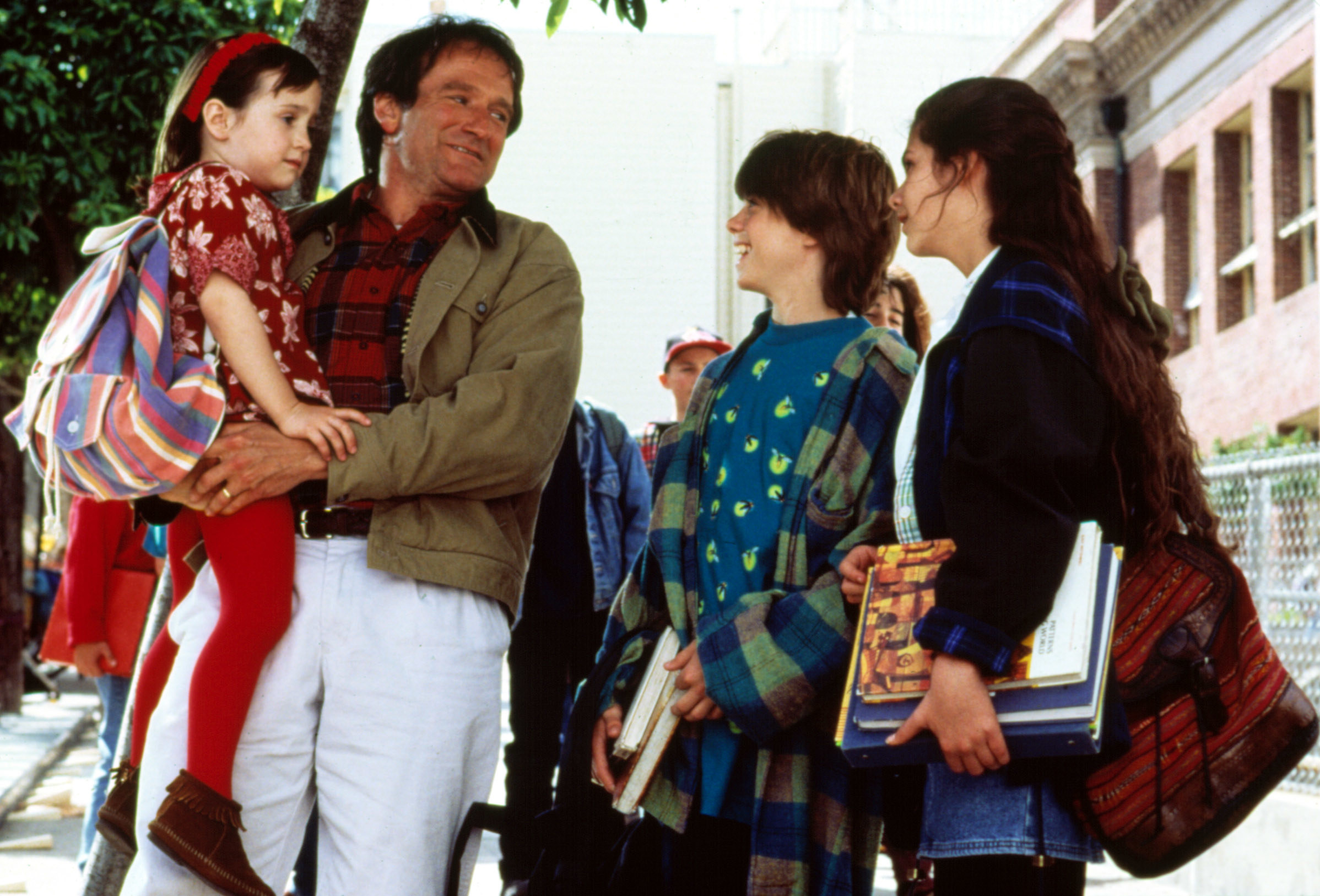 Robin Williams carrying Mara Wilson as he stands next to Matthew Lawrence and Lisa Jakub in a scene from Mrs. Doubtfire