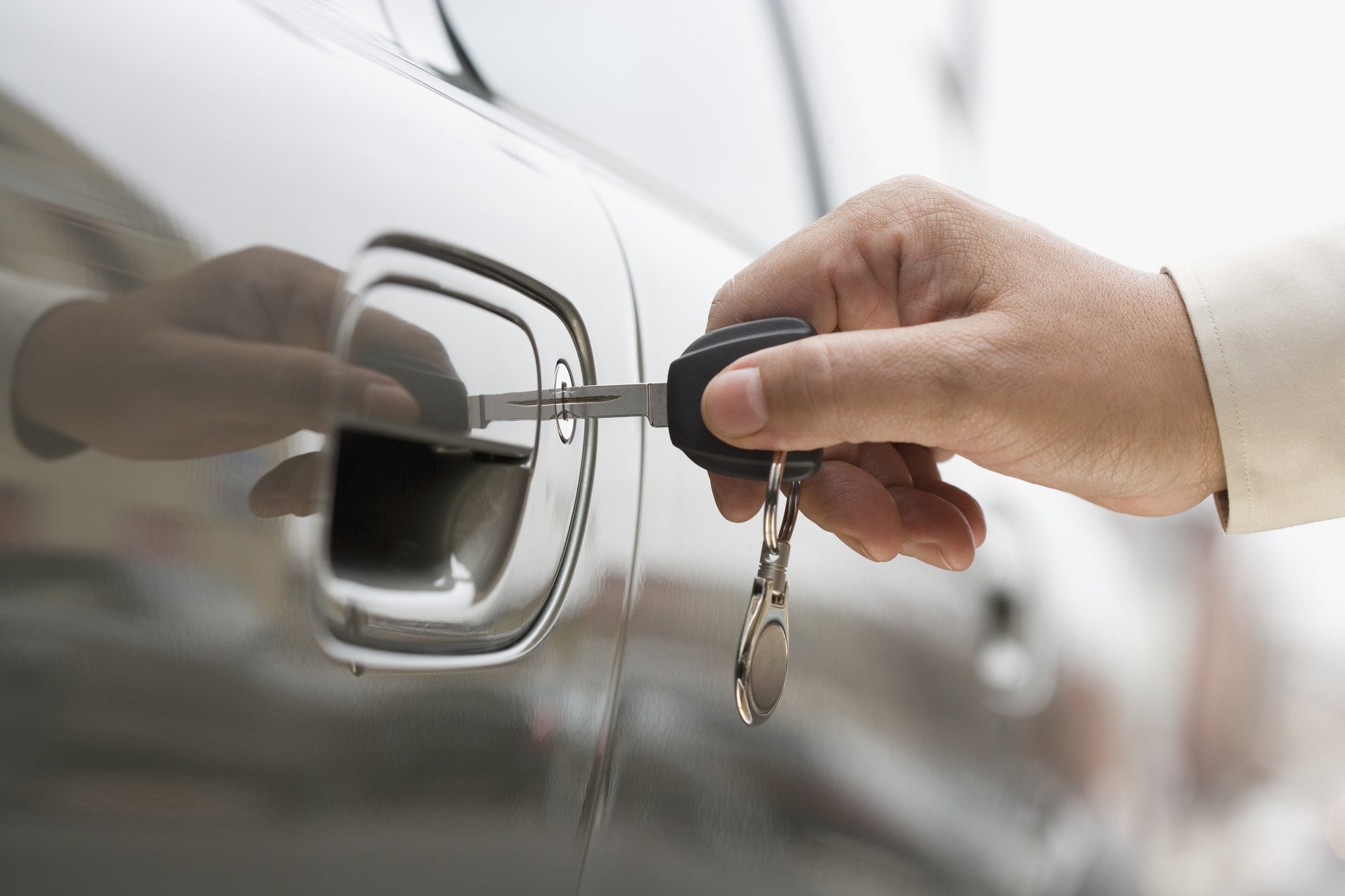 hand using a key to unlock a car