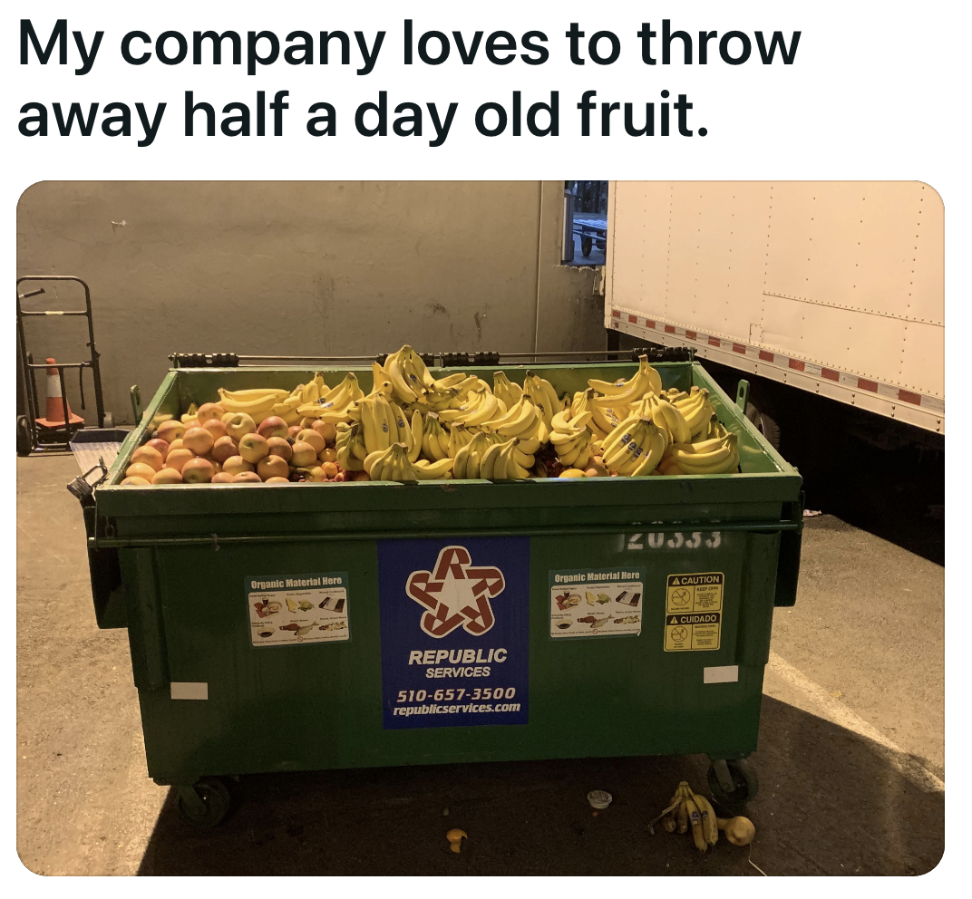 The dumpster is so full of fruit that it&#x27;s literally overflowing, with peaches and bananas spilling onto the ground