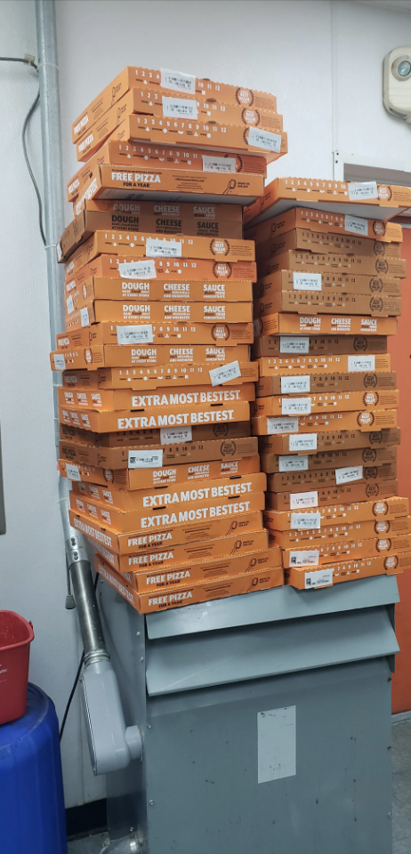Approximately 40 boxes of pizza are stacked on top of each other