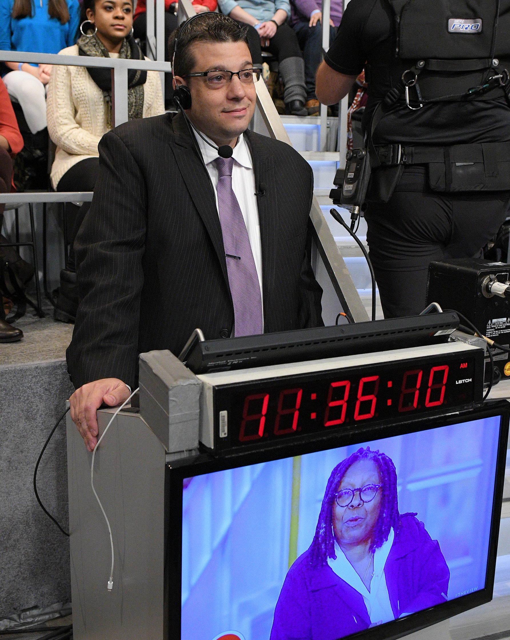 Brian standing behind a podium with a headset on