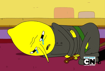 Gif of Lemongrab from Adventure Time curled up on the floor crying