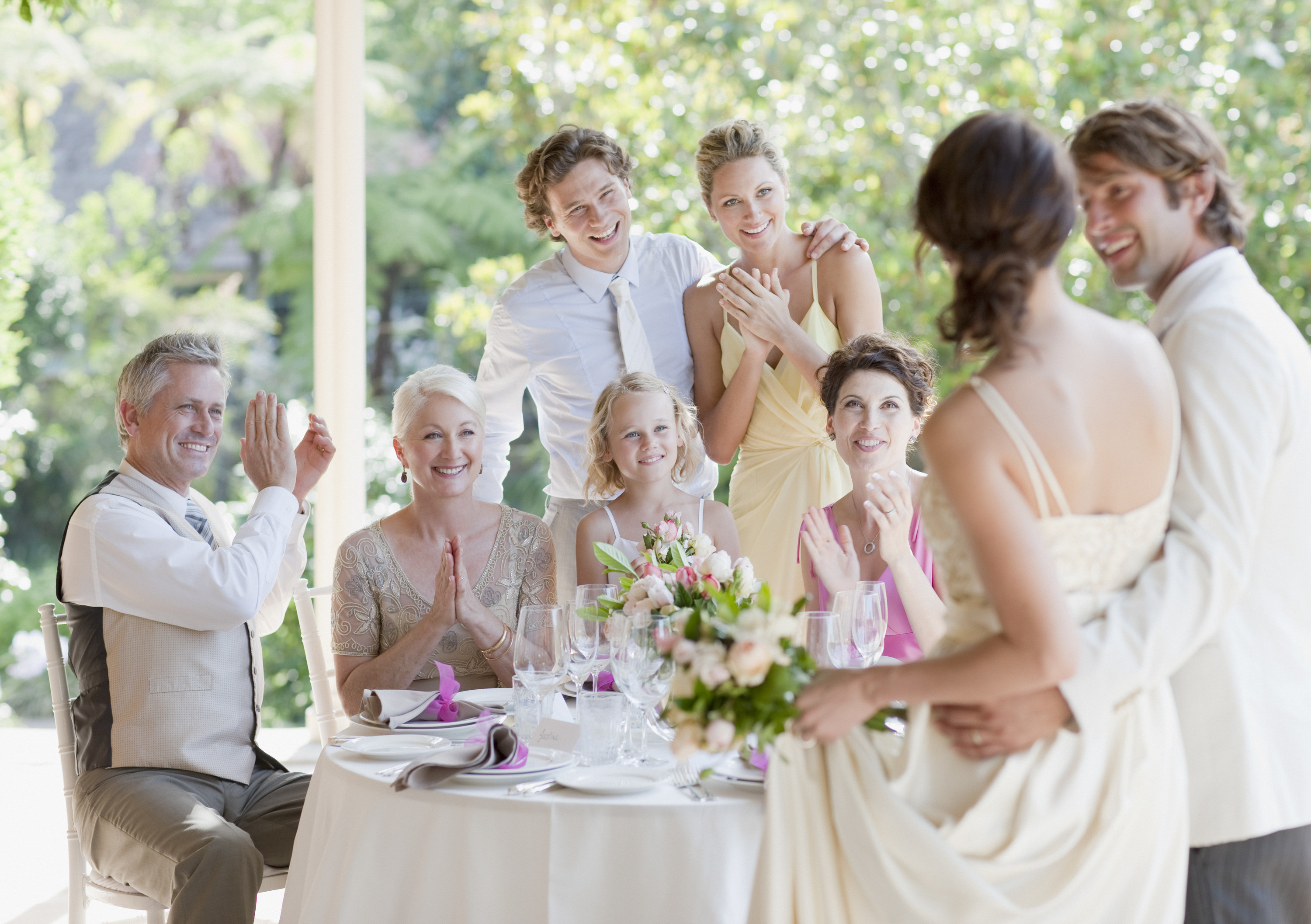 Wedding guests clap for the bride and groom at their reception
