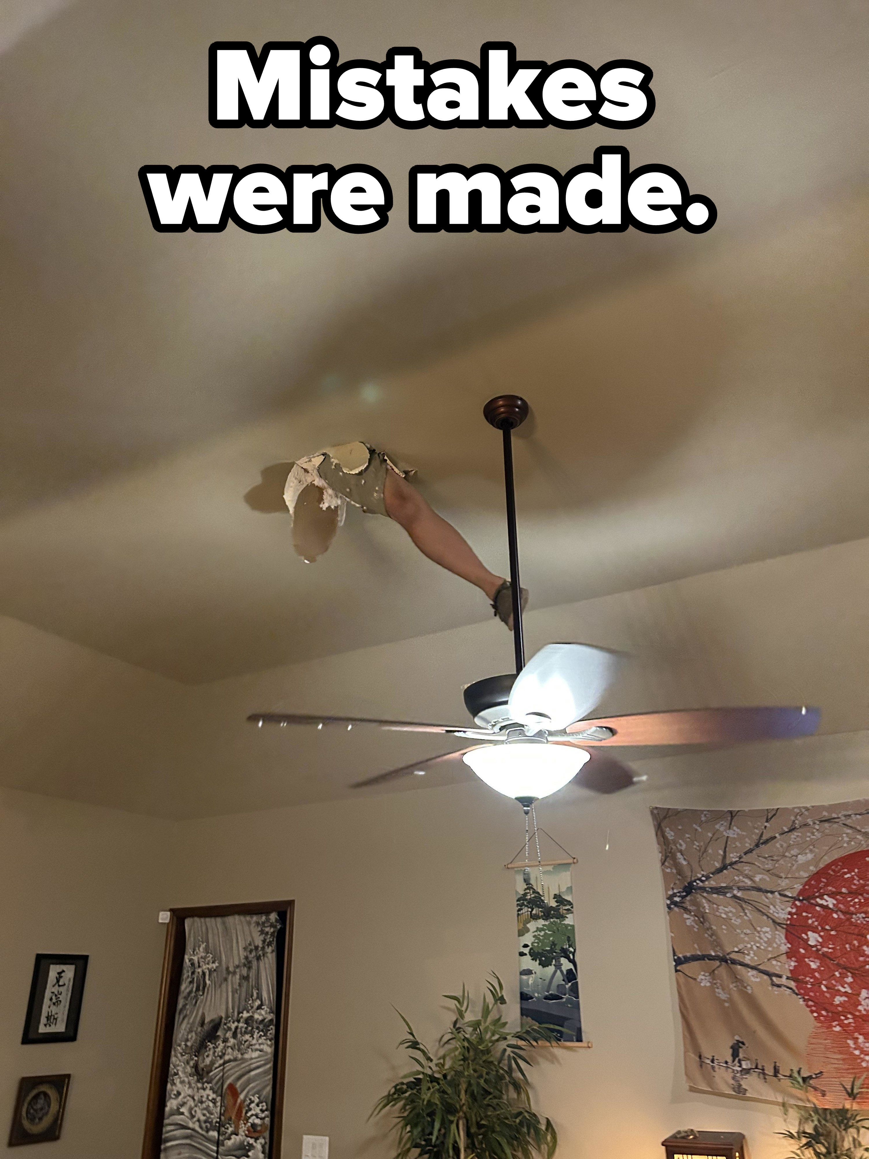 A leg jutting out of a ceiling above a ceiling fan