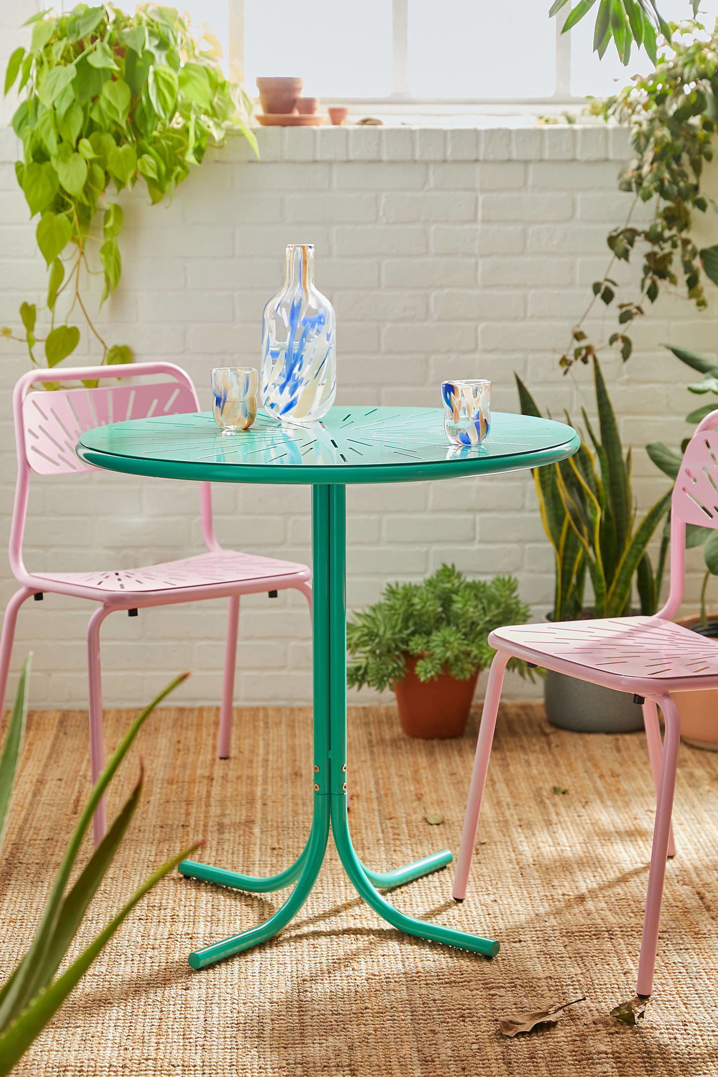 The table in green with pink chairs