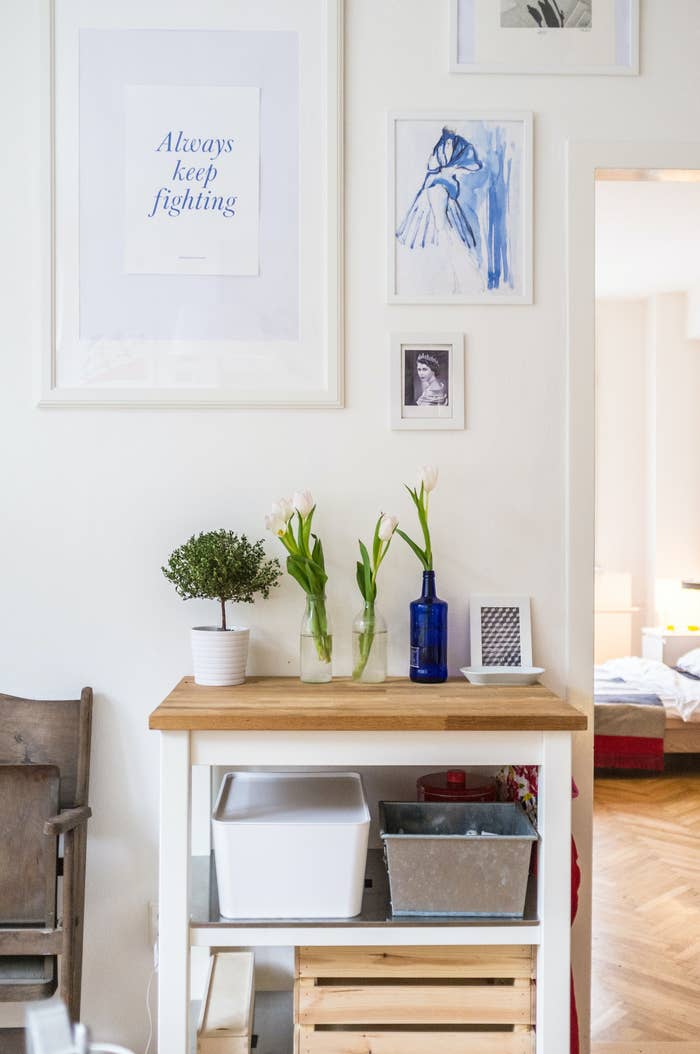 A side table with miss-matched photo frames with blue artworks inside them