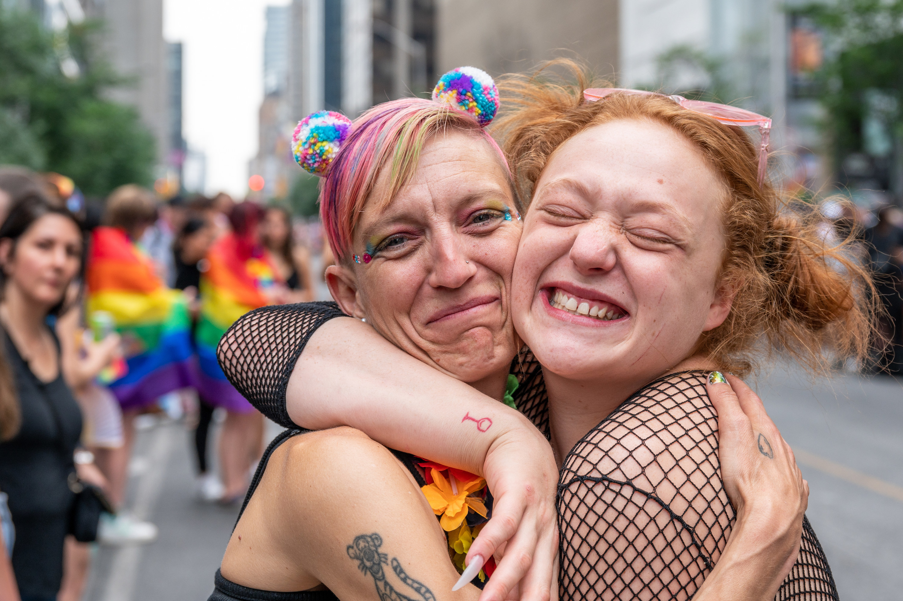 Two Toronto Pride attendees hug during the annual parade