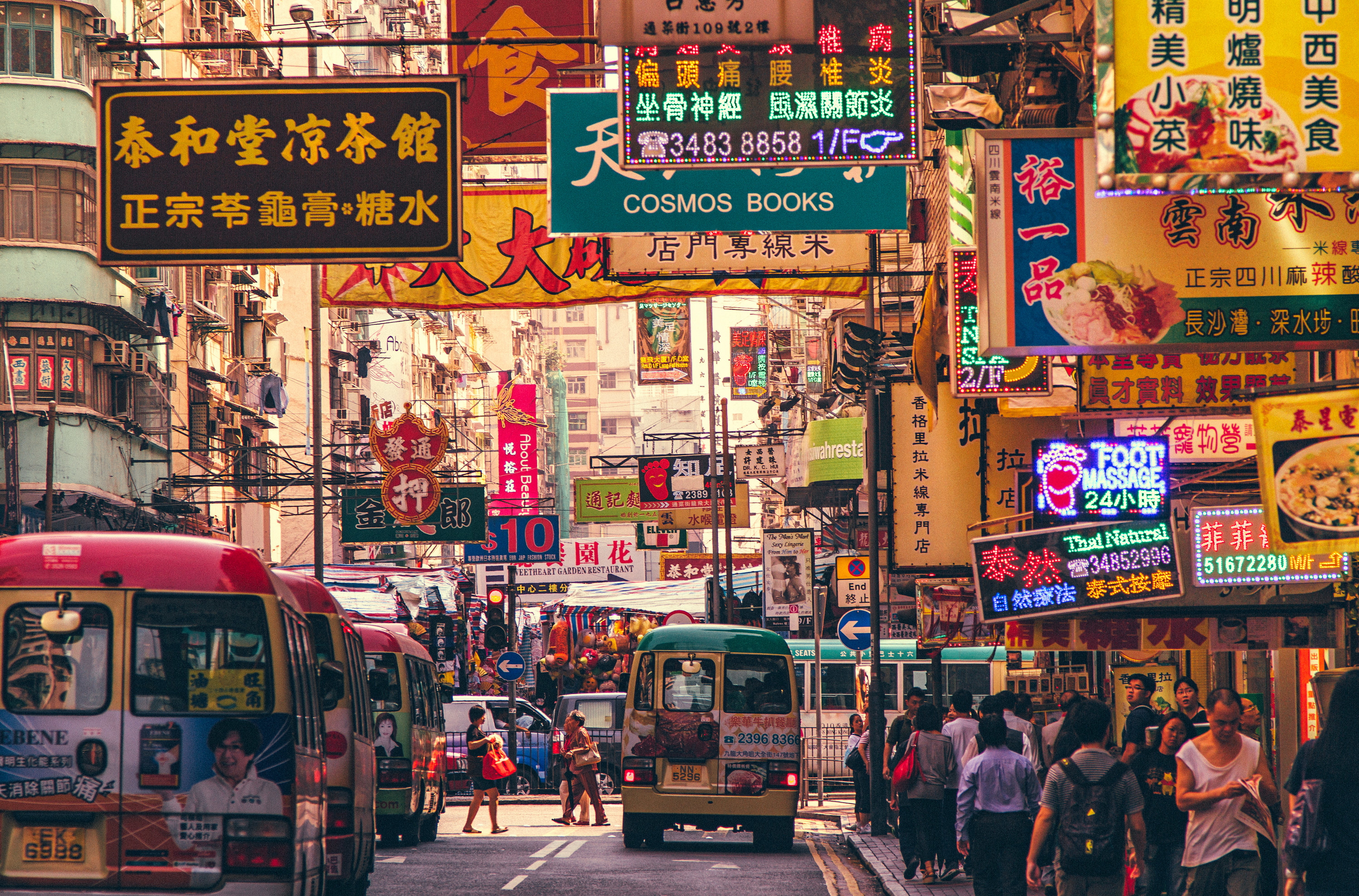 A busy street with signs and buses in Hong Kong