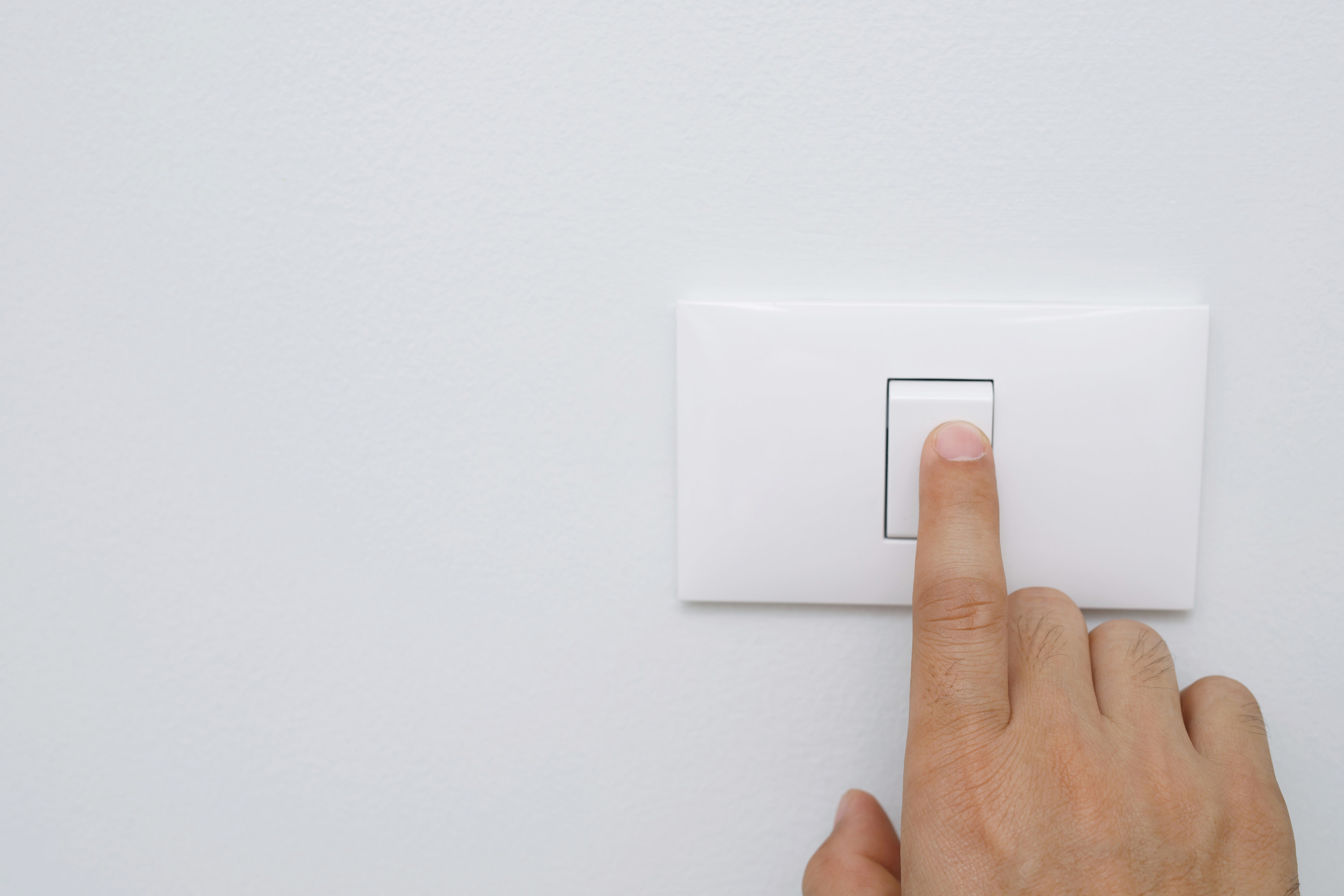 A hand flicking a light switch