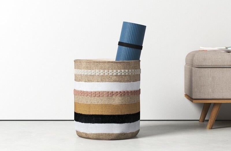 The basket with a yoga mat inside