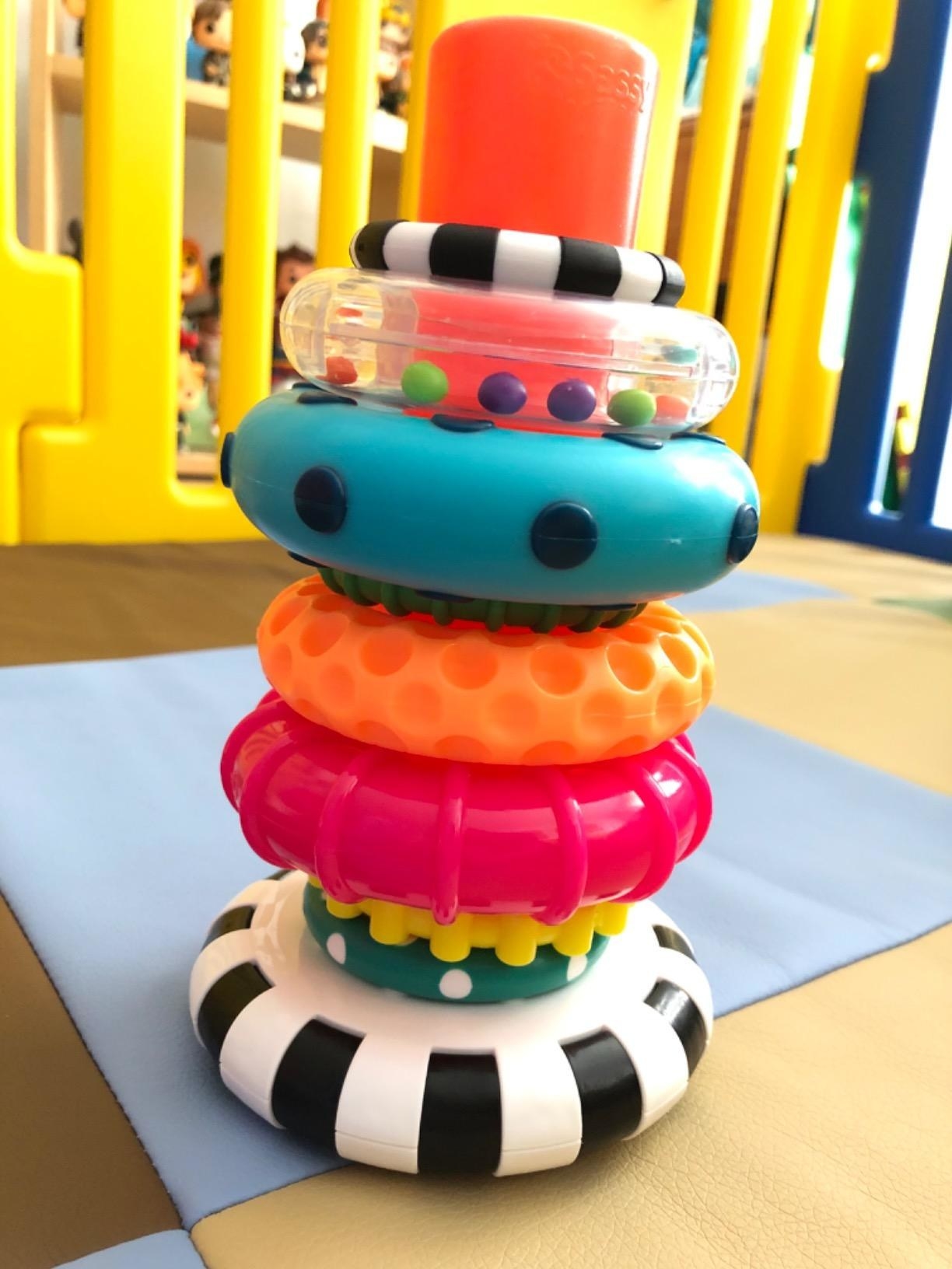 Reviewer&#x27;s photo of of multi-colored and textured ring toys stacked