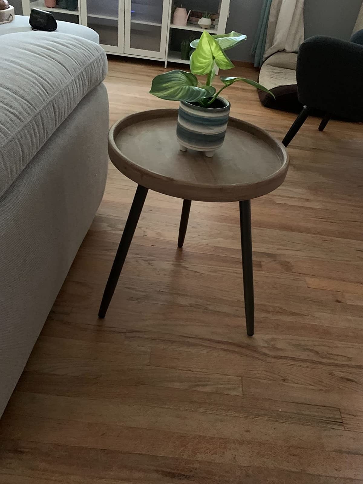 Reviewer image of the wood side table with a potted plant on it