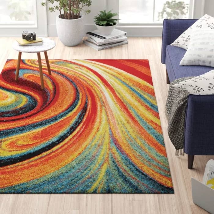 The swirl rainbow rug on a light hardwood living room floor