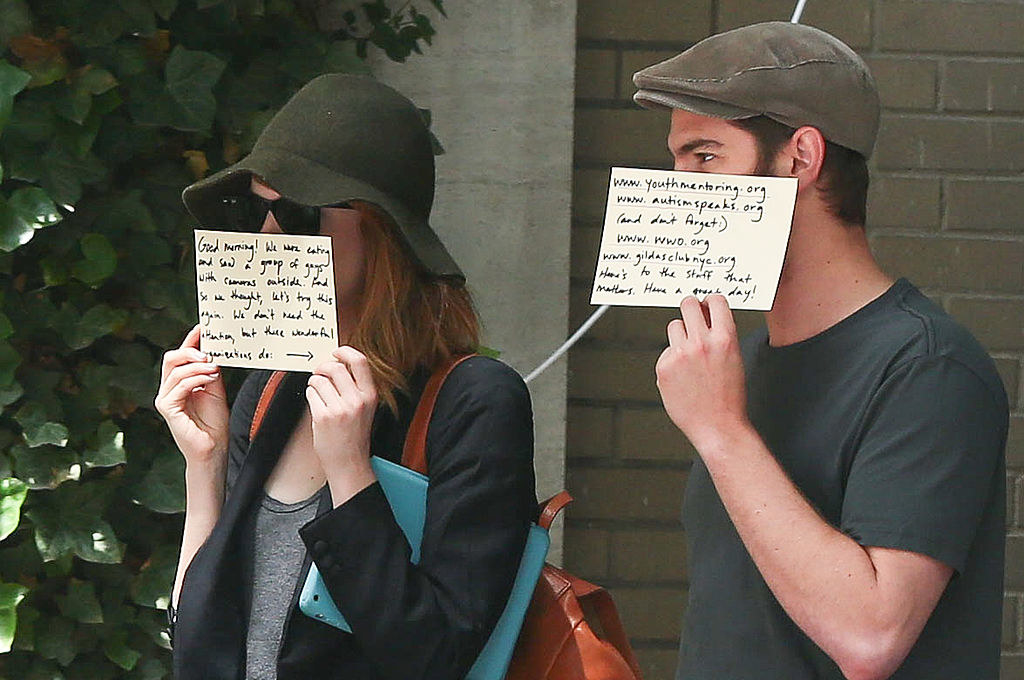 Emma Stone and Andrew Garfield holding signs