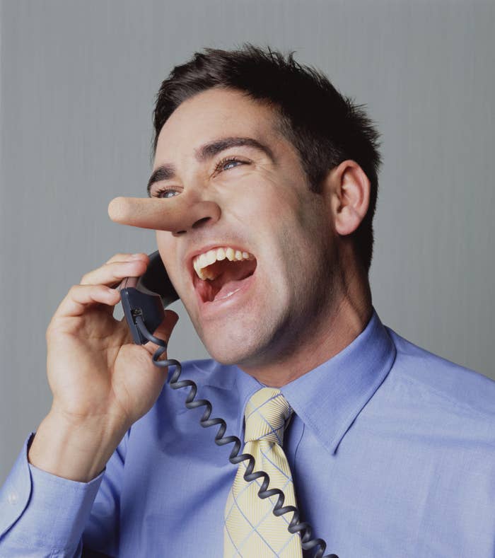 A man on the phone with his nose growing