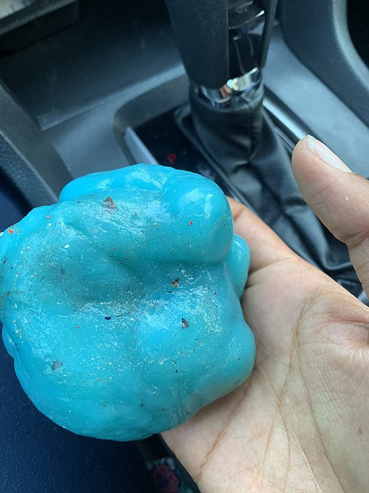 Reviewer&#x27;s photo of blue gel with dirt removed from car dashboard