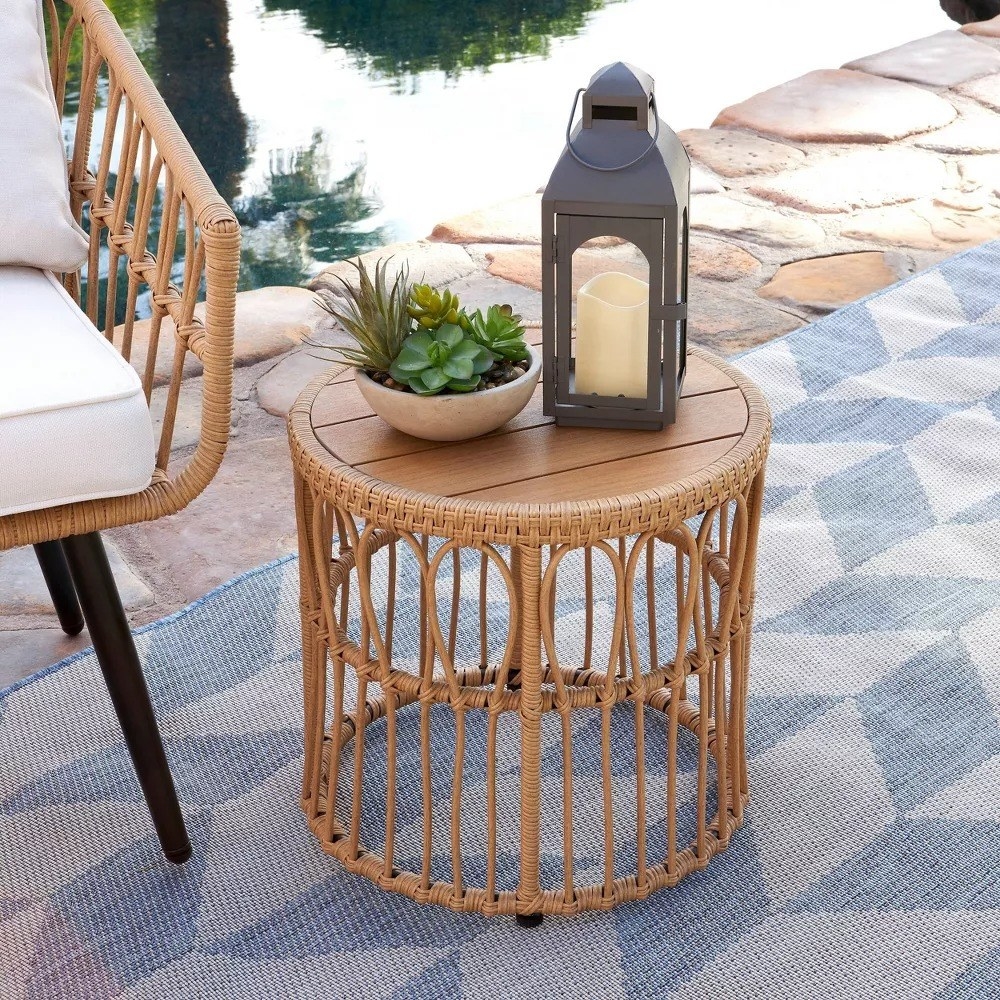 wicker circular side table with succulent plant and black lantern on top