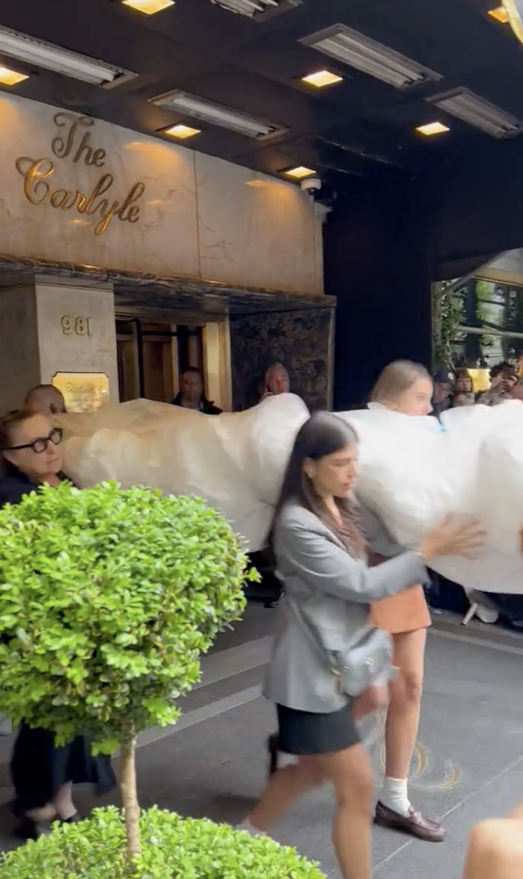 Screenshot from a video of people carrying something out of the Carlyle