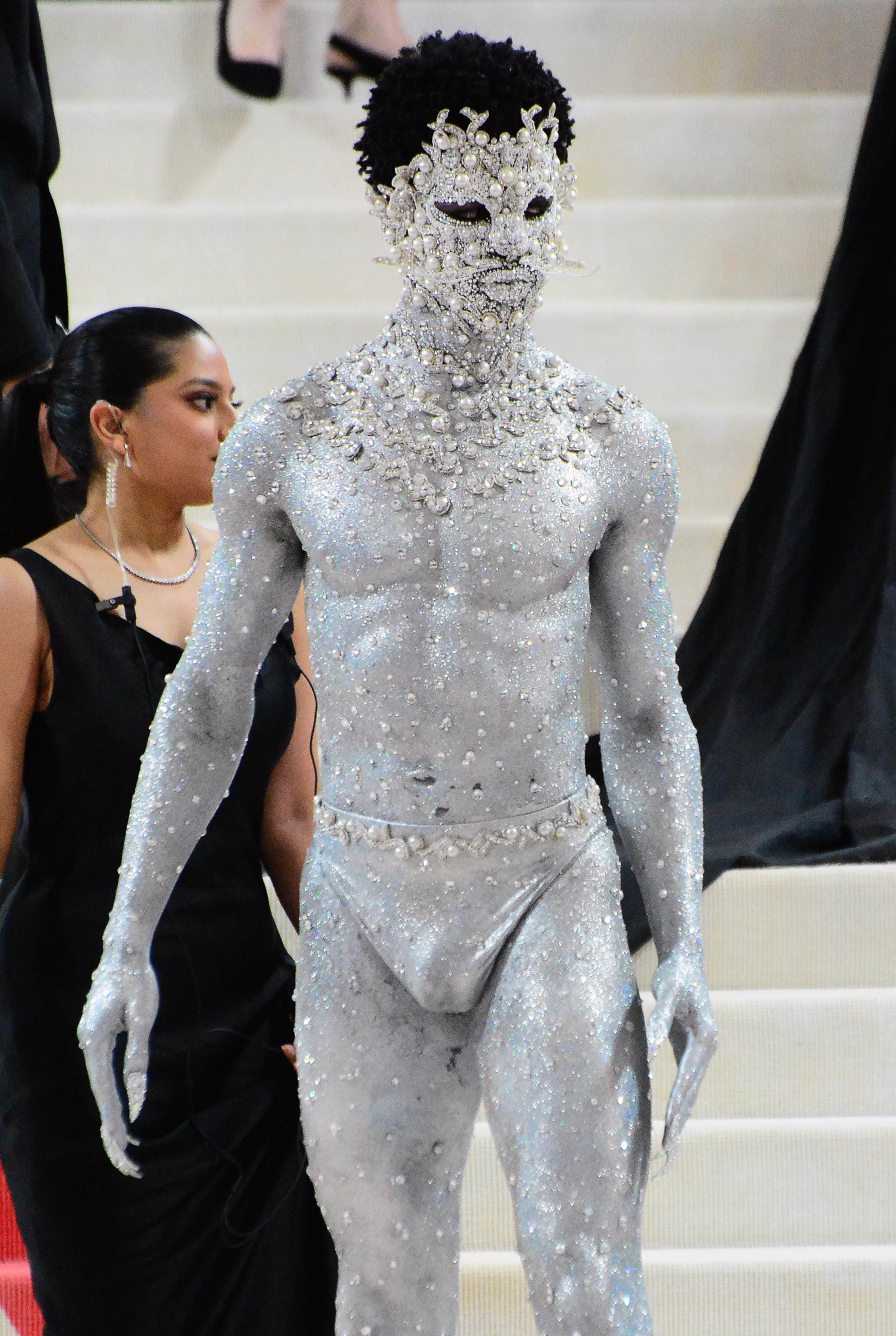 Lil Nas X poses on the Met Gala red carpet wearing full glitter bodypaint a jewel-encrusted face mask