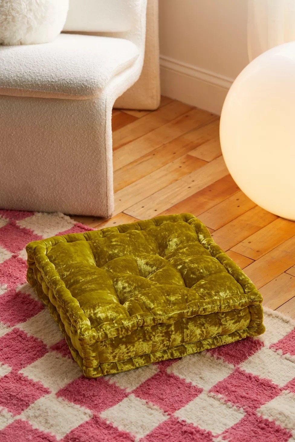 Chartreuse floor pillow on a checkered rug