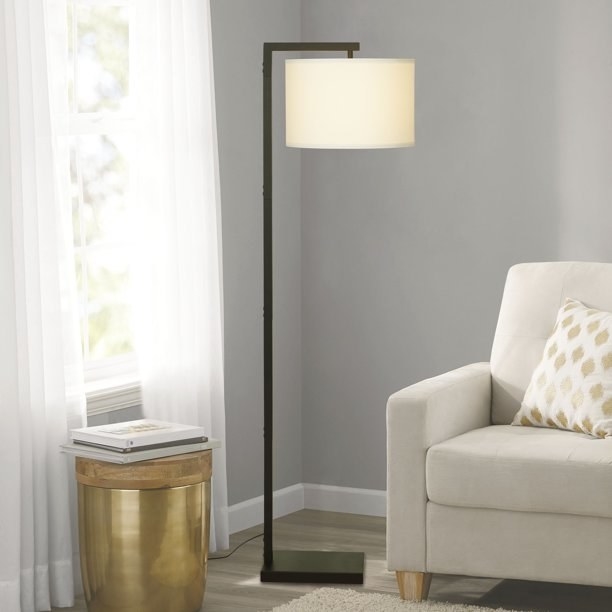 Floor lamp next to an armchair and gold side table
