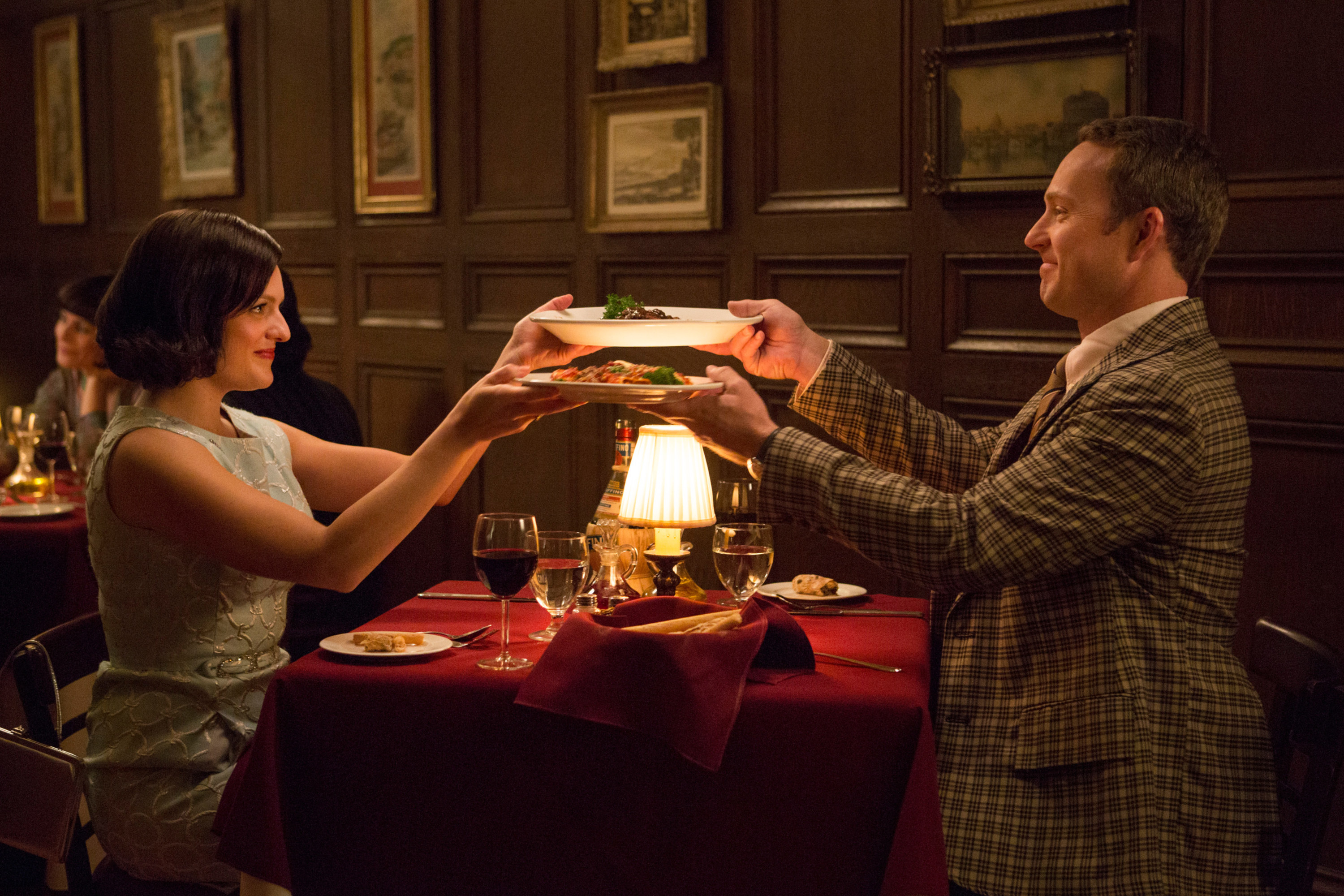 A couple swapping plates at dinner