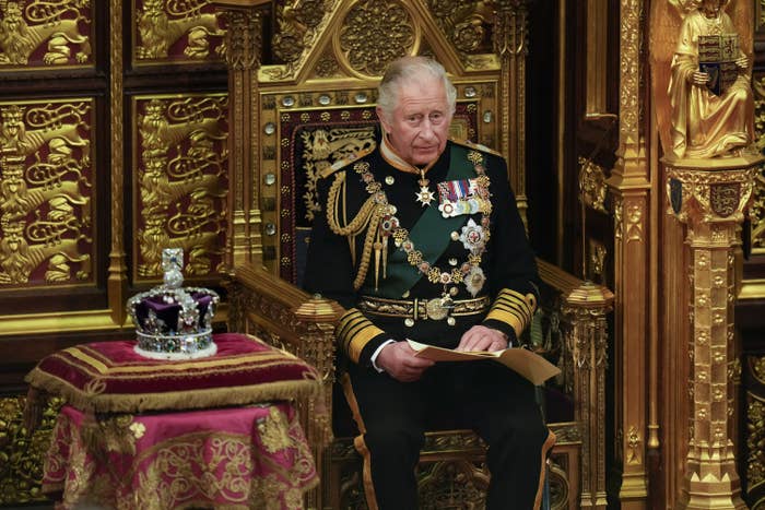 charles sitting on a royal throne next to the crown