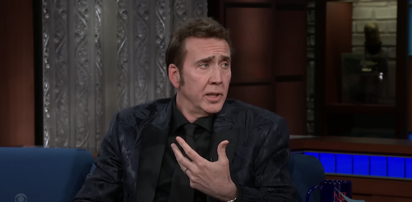 Closeup of Nicolas Cage talking to Stephen Colbert