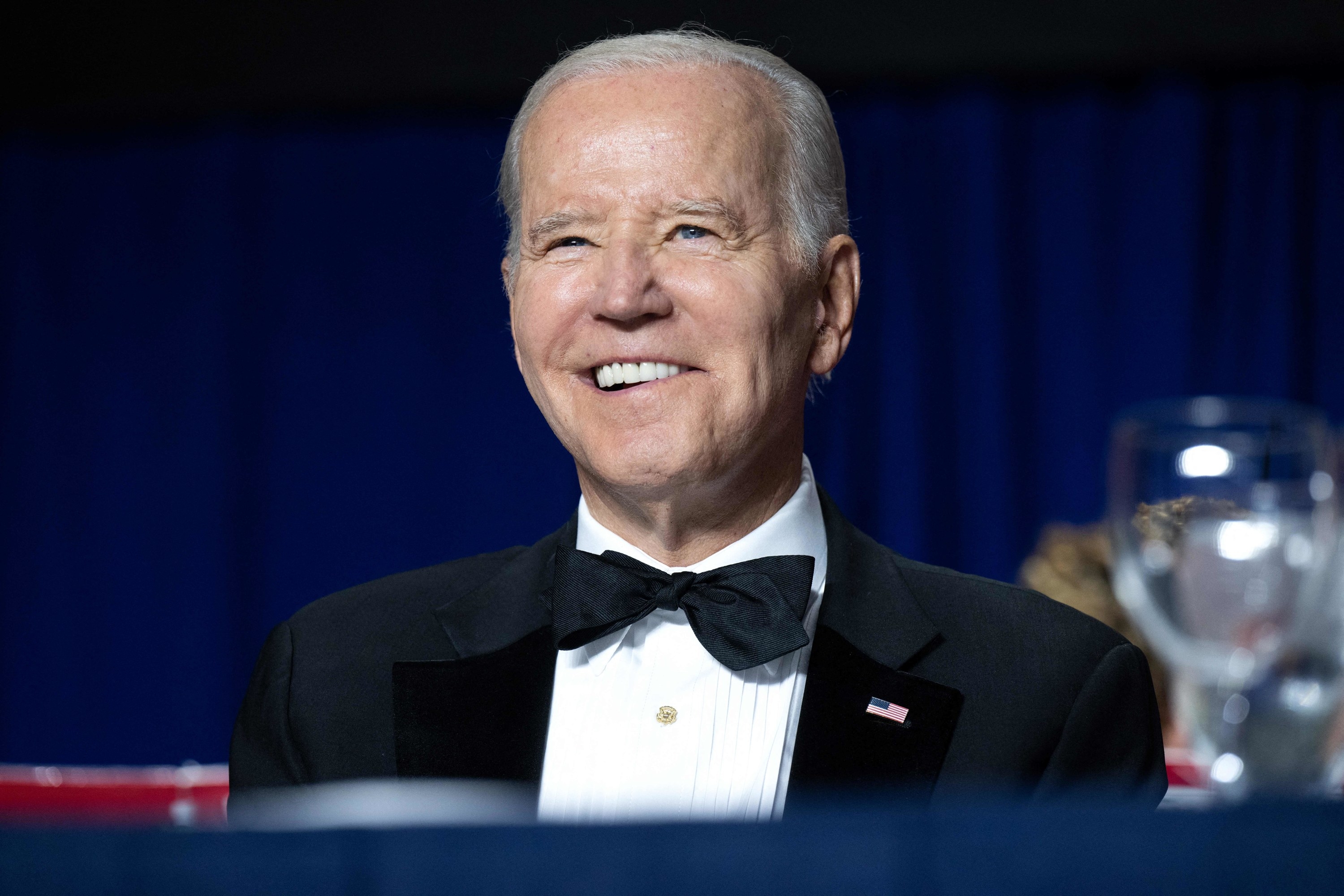 A closeup of President Biden smiling at a black tie event