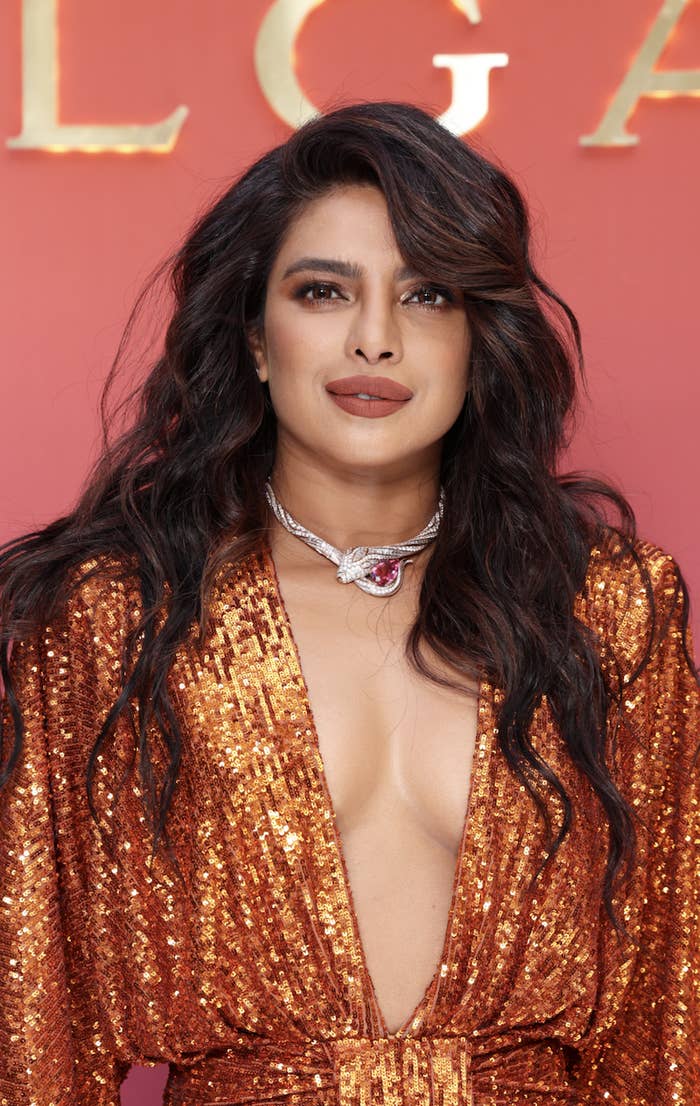 Closeup of Priyanka Chopra wearing a v-neck sequined dress and a diamond glass