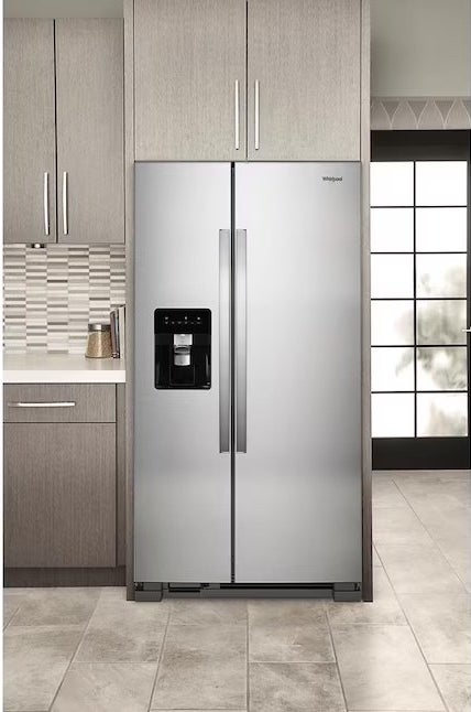 a stainless steel refrigerator in a kitchen with tiled flooring