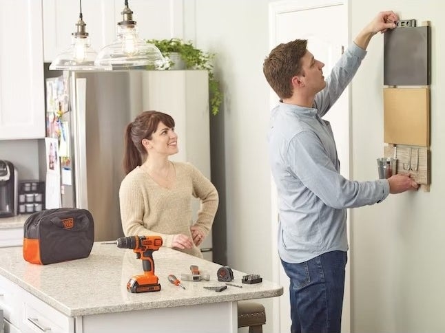Two people using a tool kit in their home