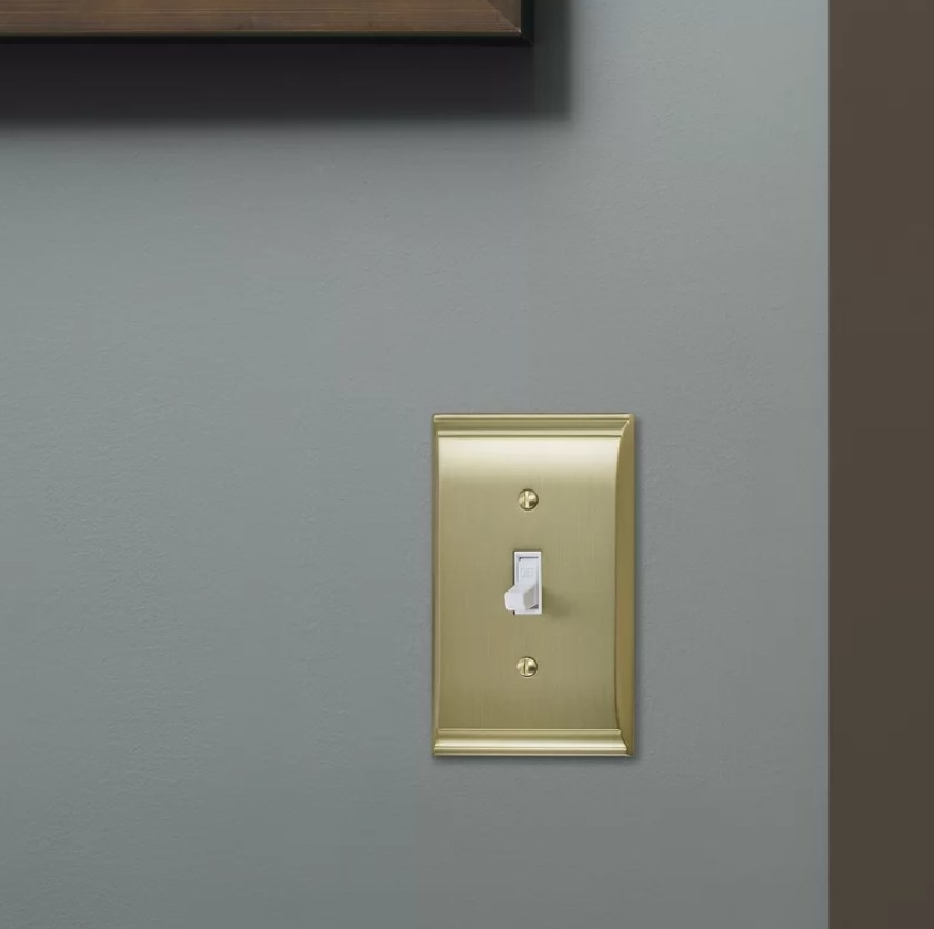 The gold light switch plate on a wall