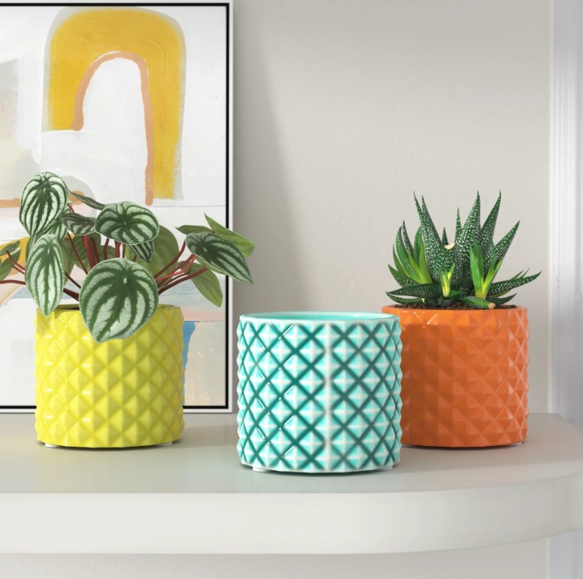 The three vases on a shelf in yellow, blue, and orange