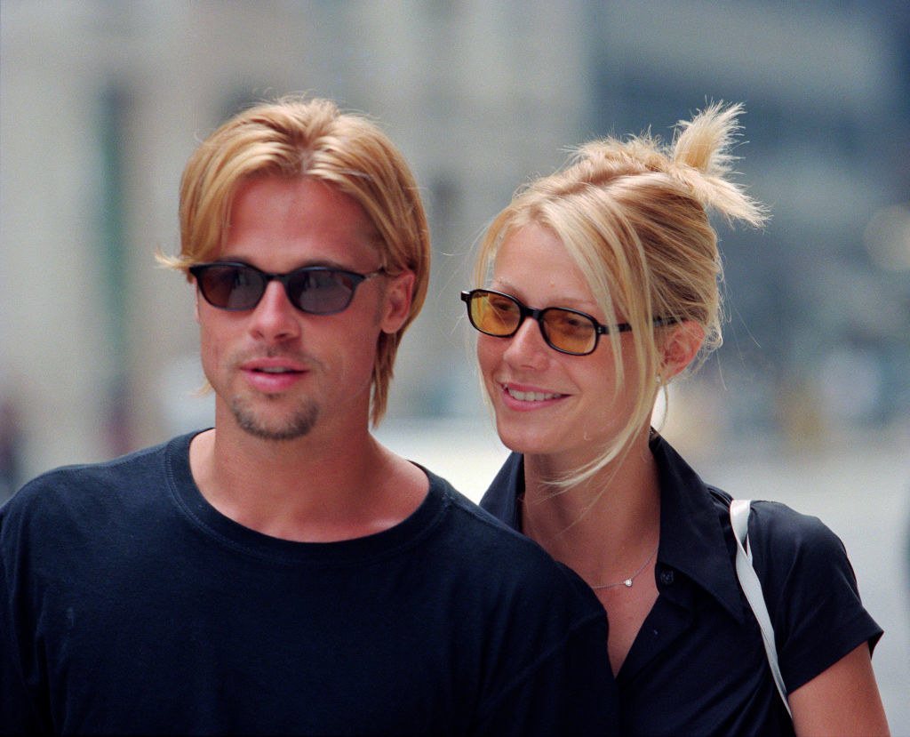 Closeup of Brad Pitt and Gwyneth Paltrow walking down the street, both wearing sunglasses