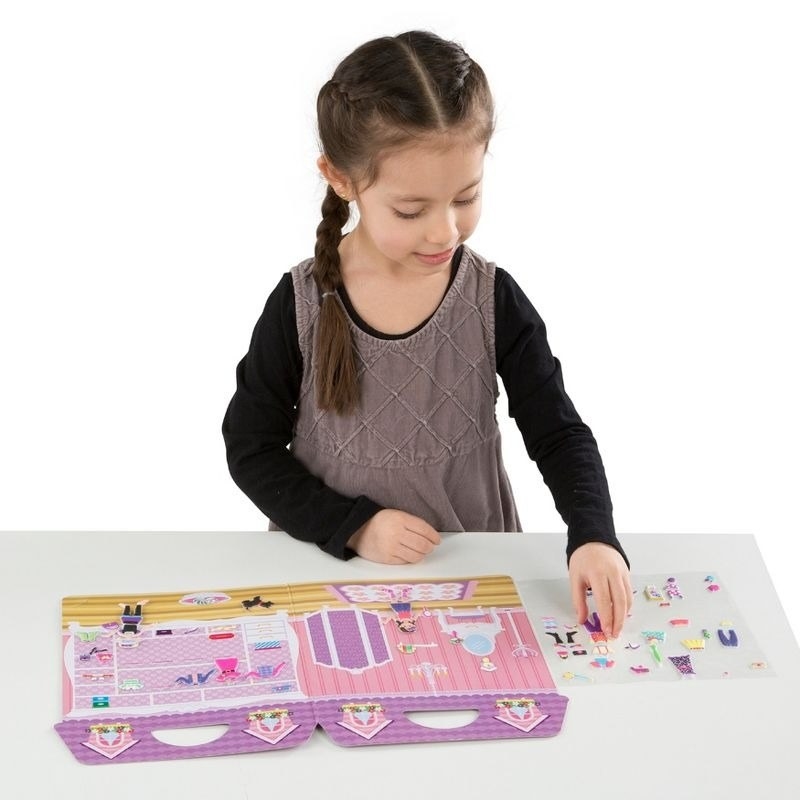 Child plays with a sticker book