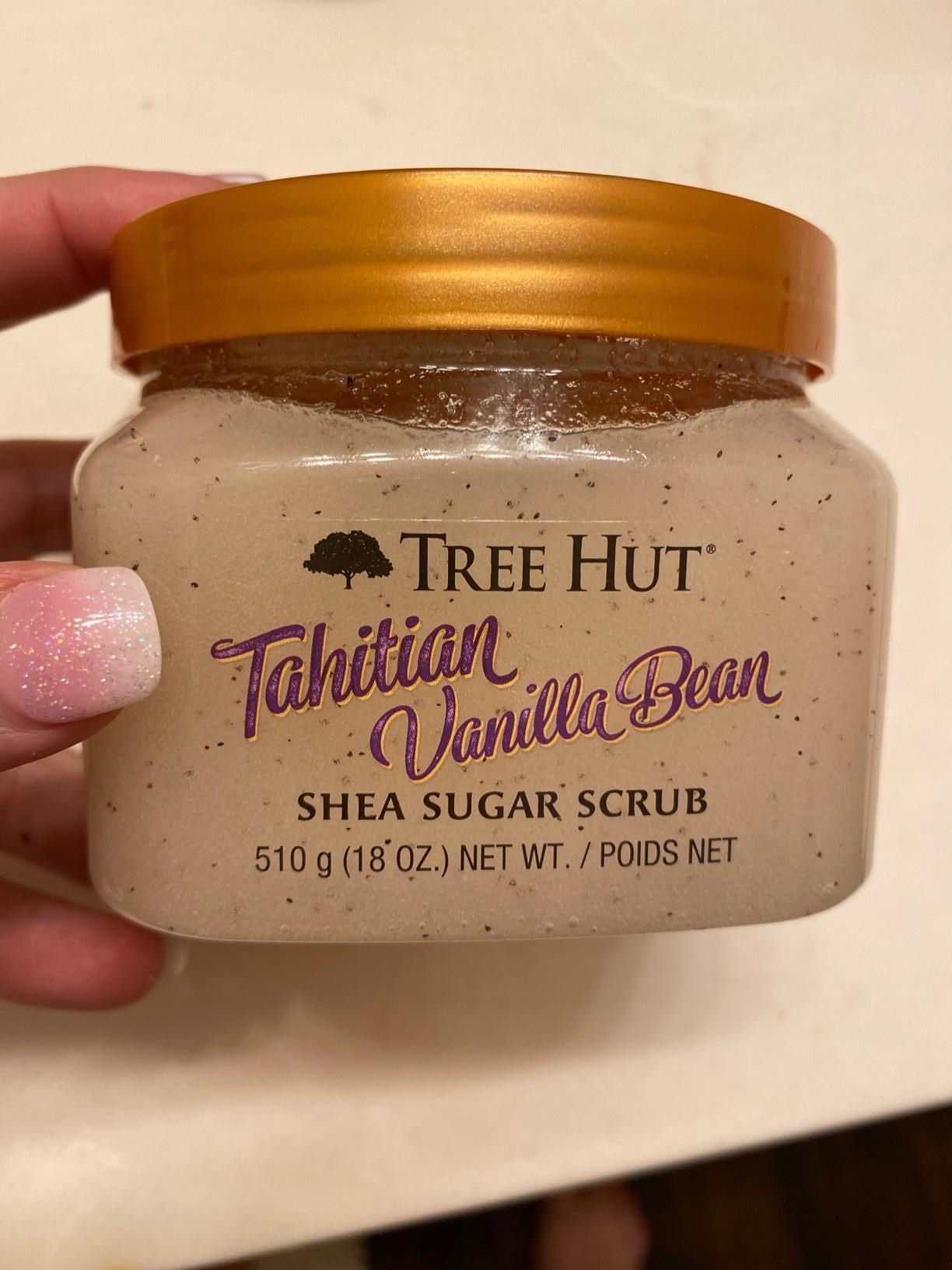 Reviewer holding a tub of the scrub