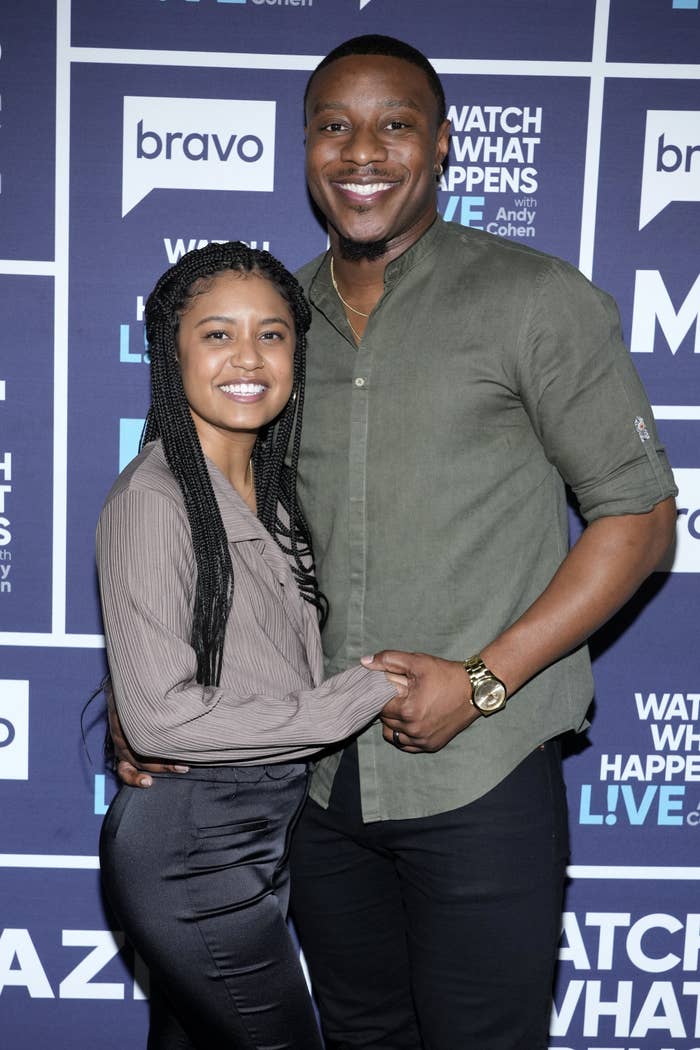 Closeup of Iyanna McNeely and Jarrette Jones holding hands at a red carpet event and smiling for photographers