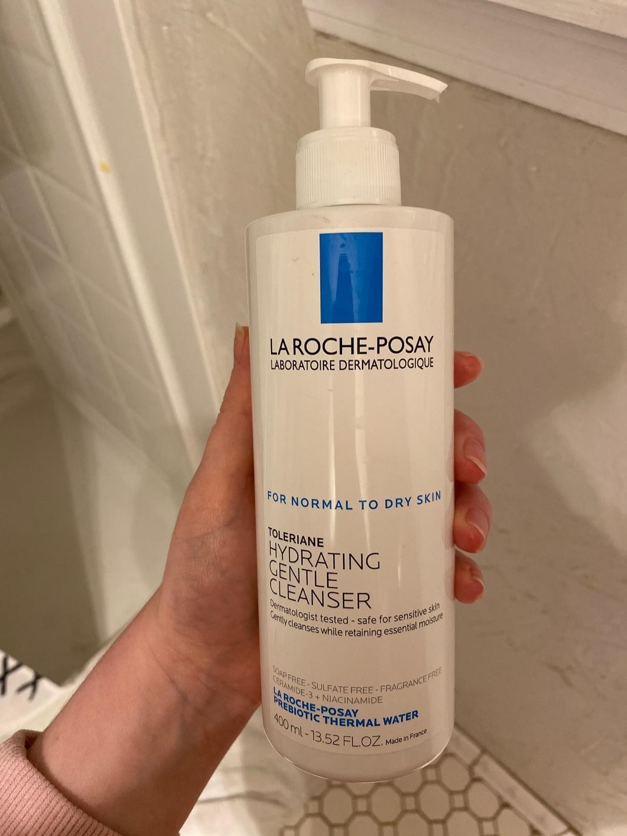 Reviewer holding the bottle of cleanser