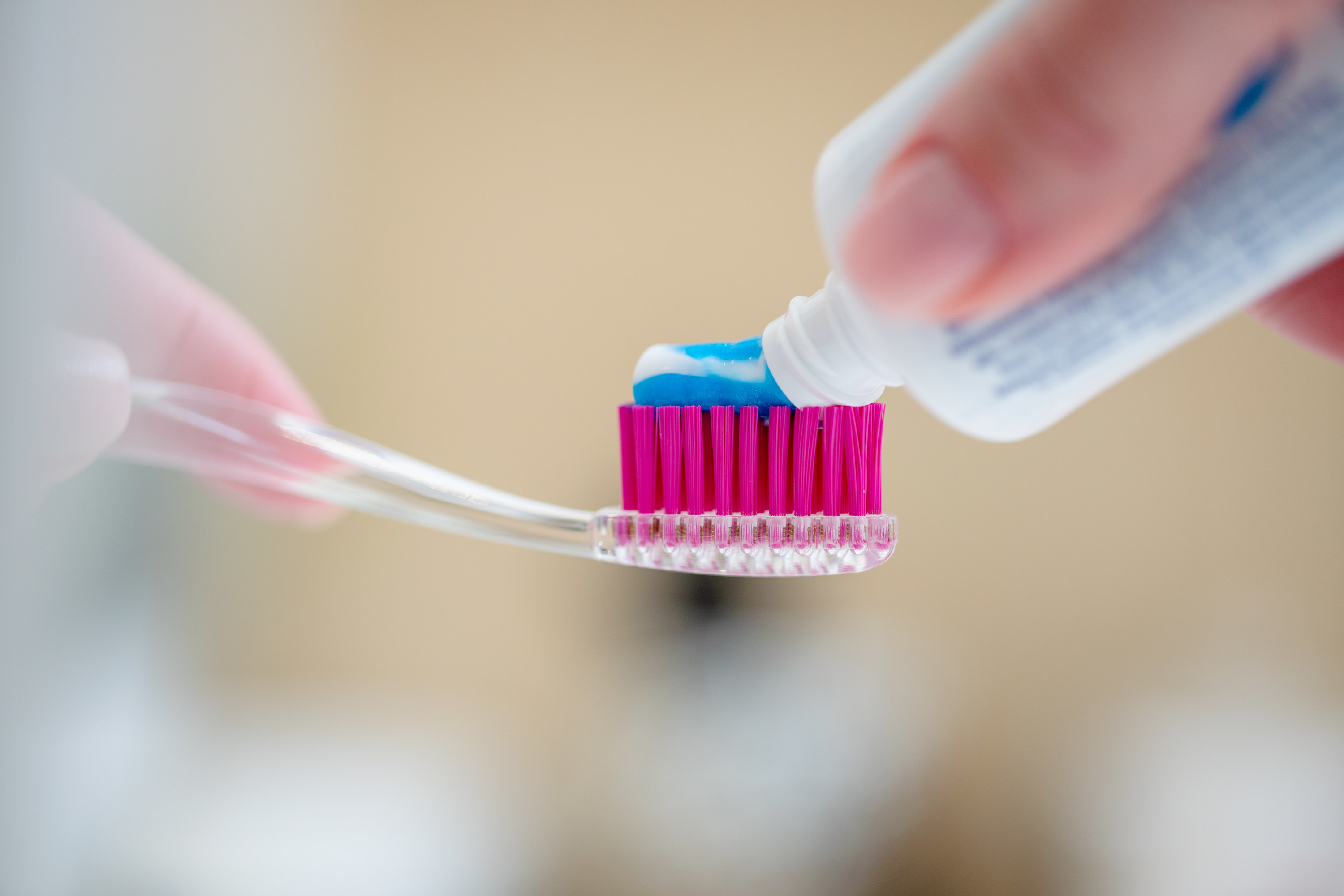 Close-up of toothbrush and a tube of toothpaste in a woman&#x27;s hands