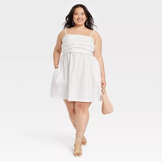 A model in the white spaghetti strap dress