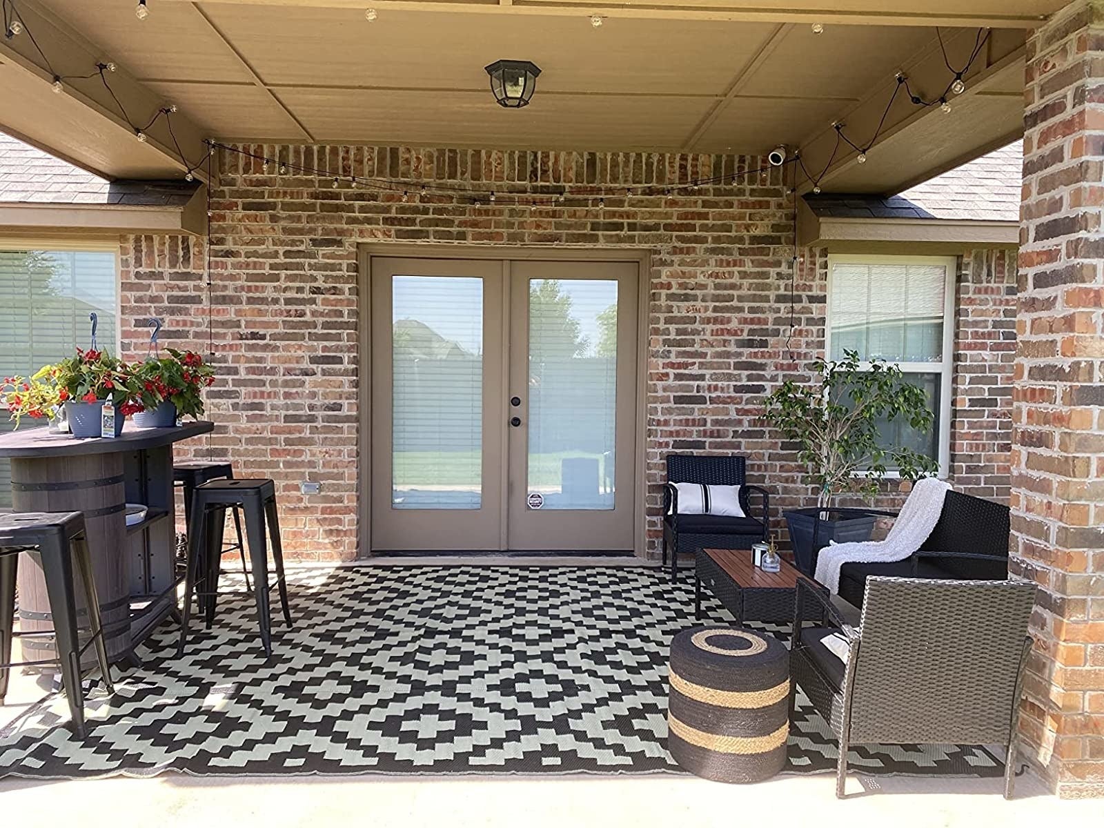 Reviewer image of the rug on their patio with outdoor furniture set up