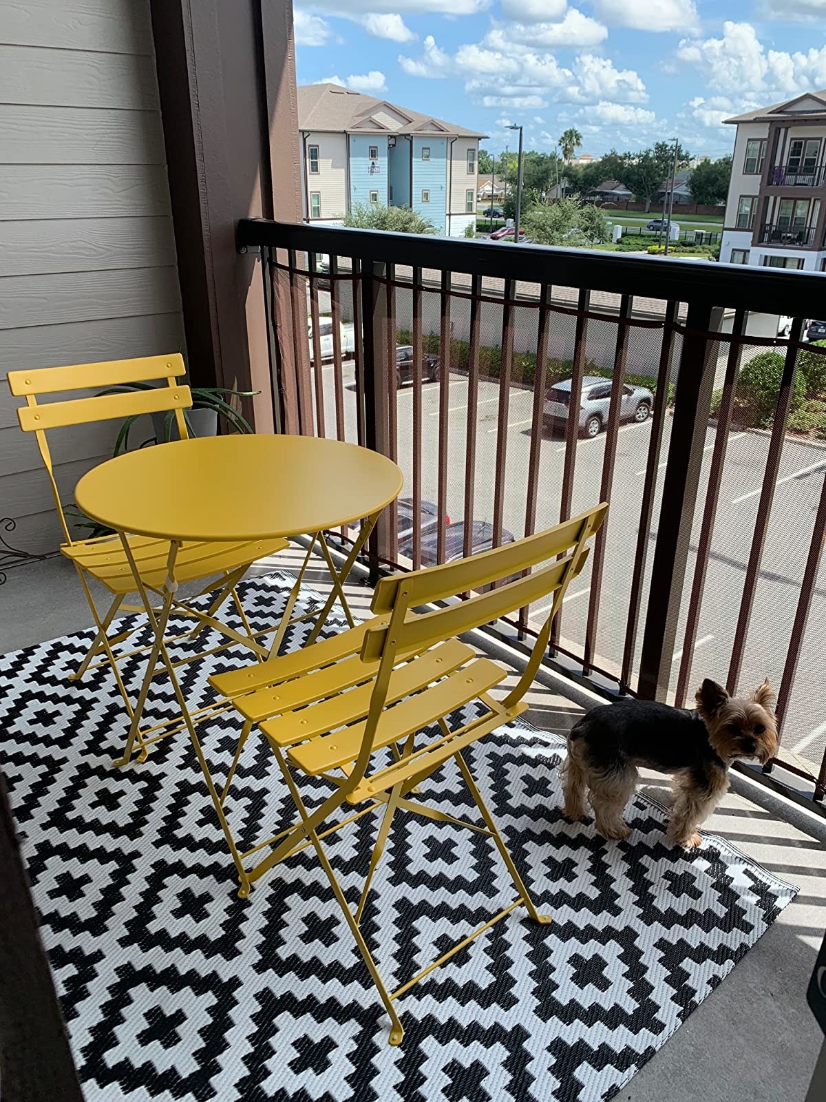 Reviewer photo of the bistro set in yellow on a patio