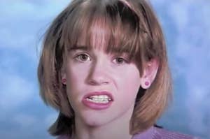 Young Jenna from 13 Going on 30 smiling awkwardly for her yearbook photo