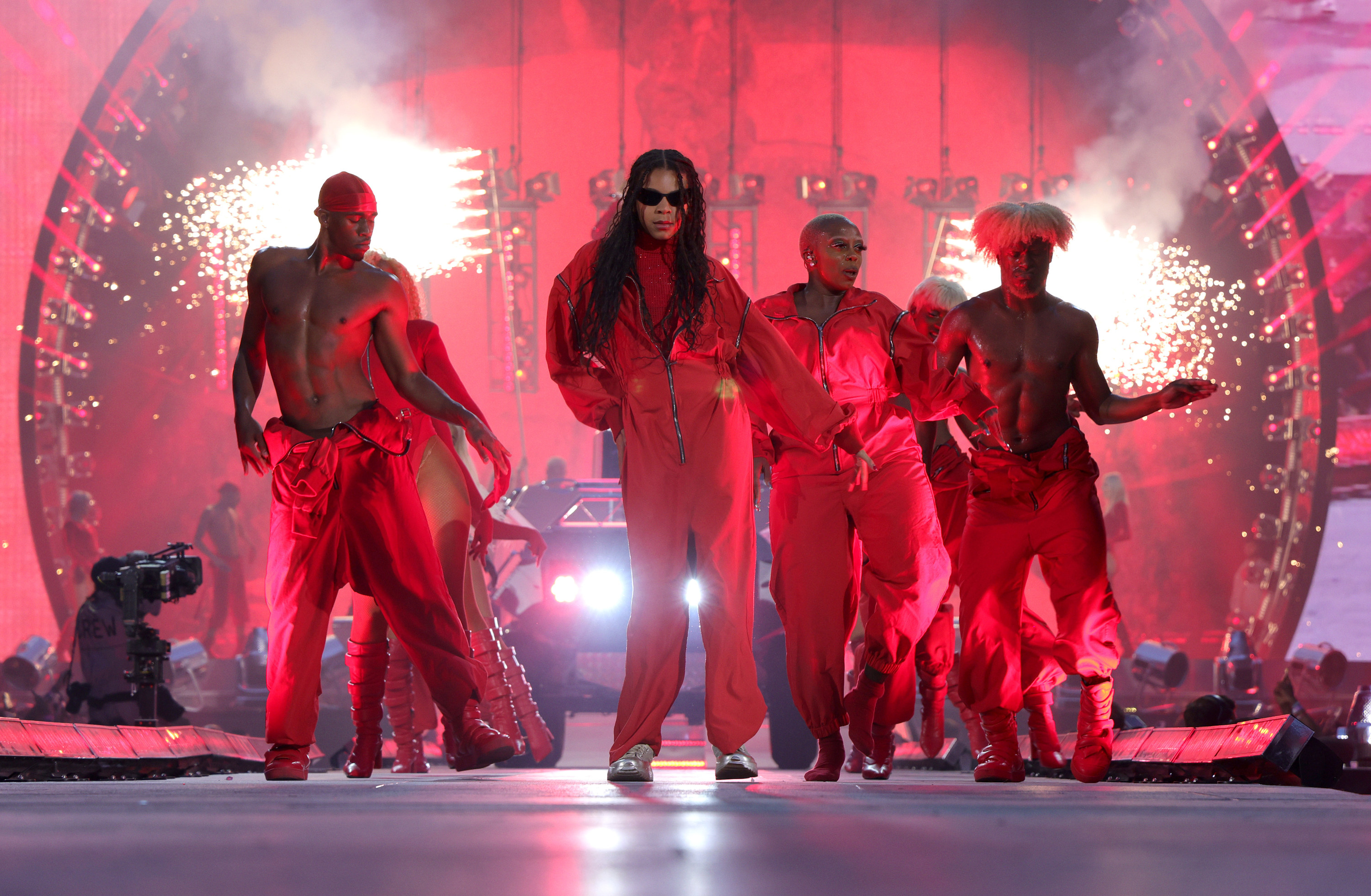 Blue stands in front of dancers