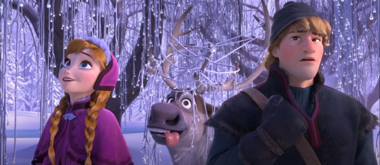 Anna, Sven the reindeer and Kristoff walking through a frozen forest in Disney&#x27;s Frozen