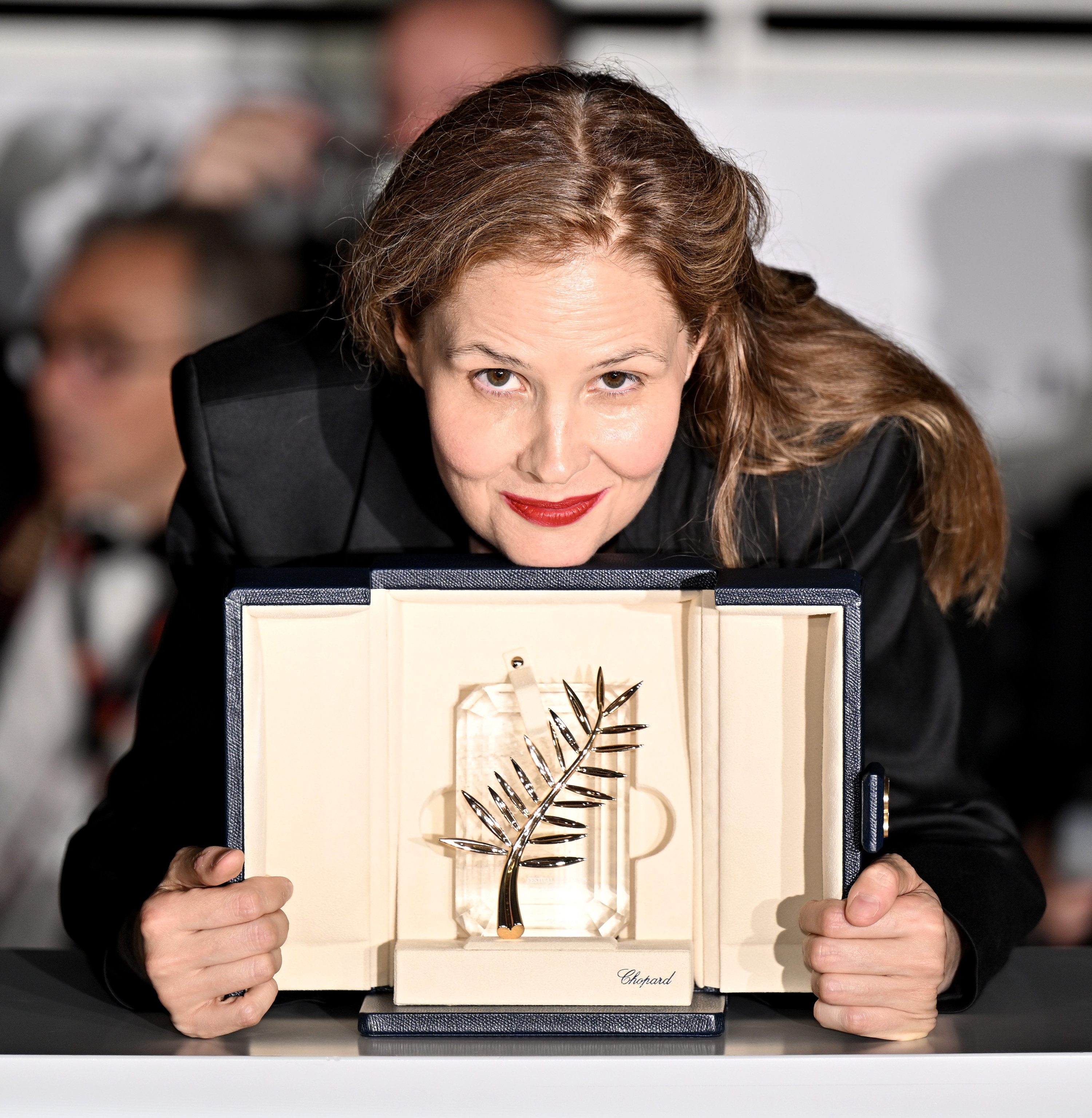 justine triet poses with her award at the cannes film festivla