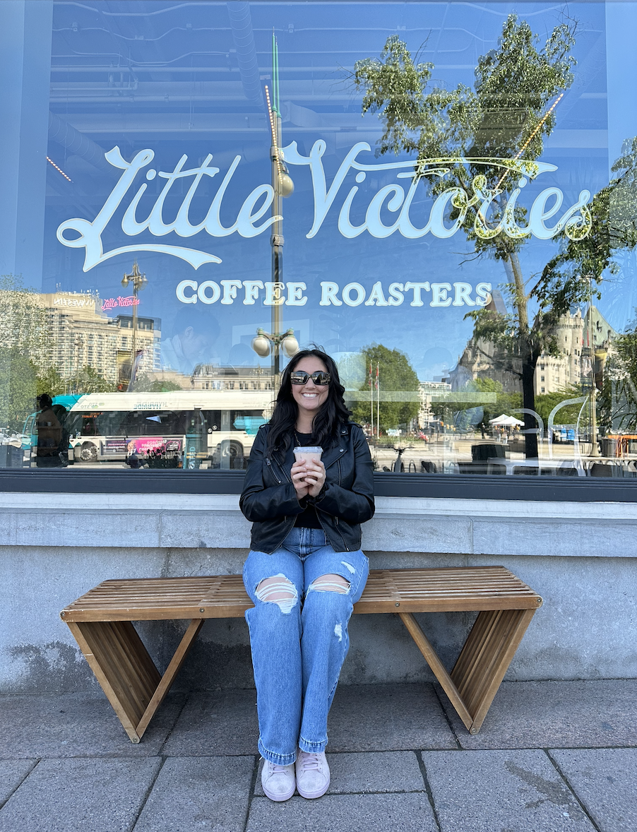 The writer drinking a coffee in front of Little Victories Coffee Roasters
