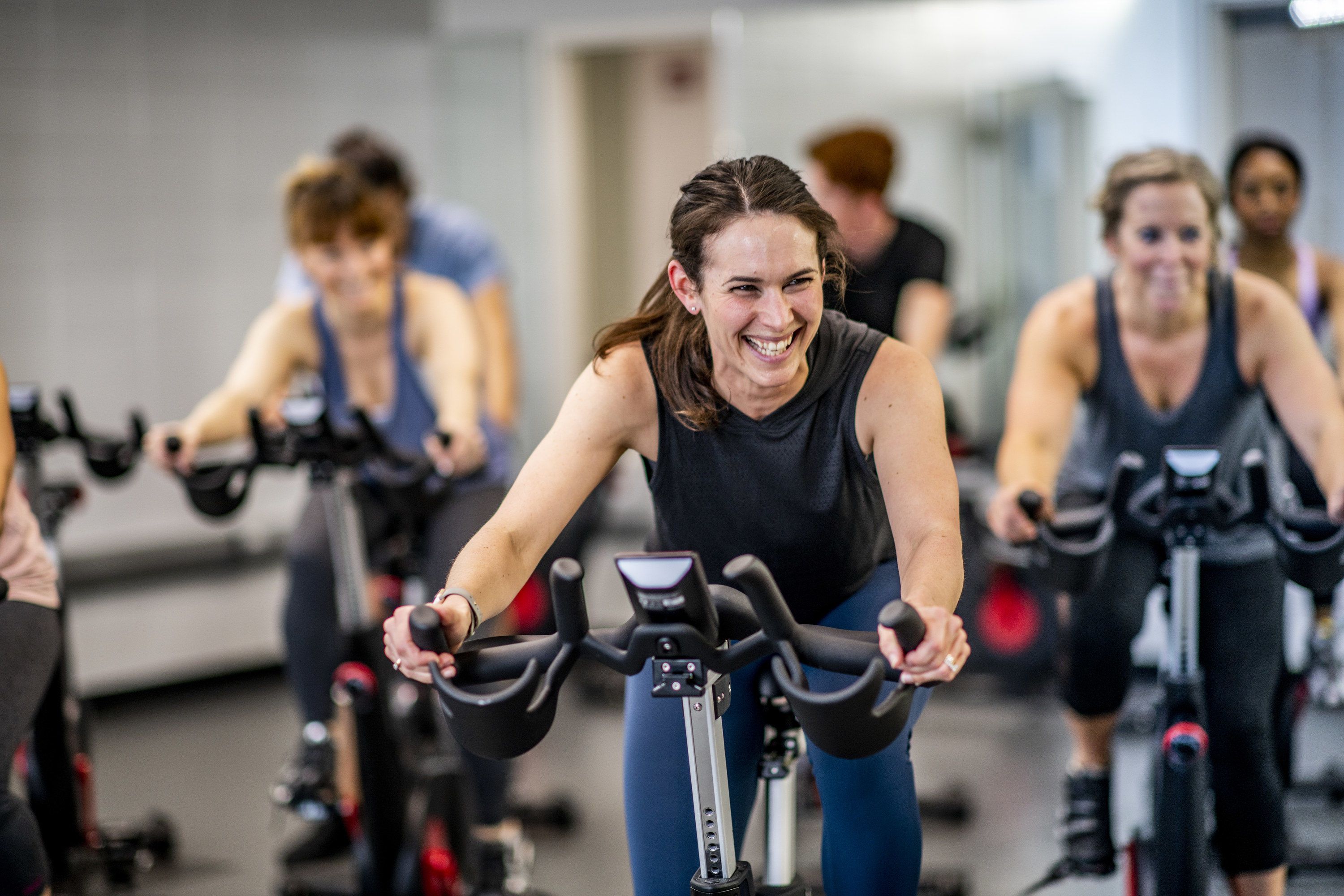 A woman smiles during a cycling class at the gym