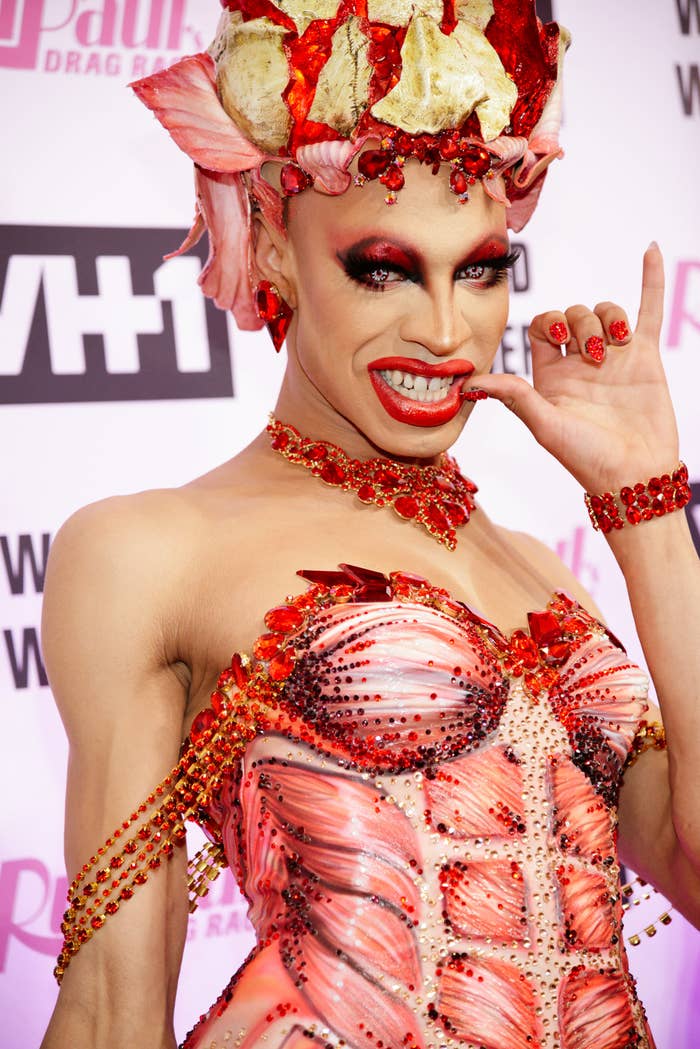 yvie oddly poses on a red carpet in a an outfit that depicts the muscles on the inside of the body